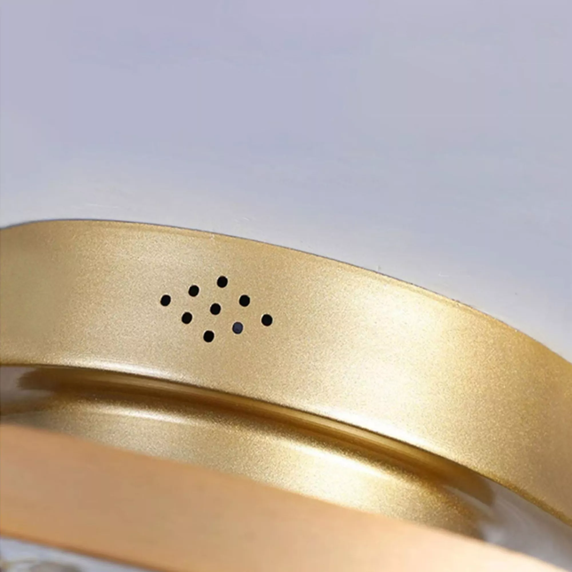 Gold-finished metal frame of ceiling fan light showing air vents