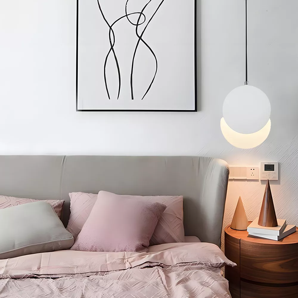 White globe pendant lamp illuminating a cozy bedroom nightstand with soft light