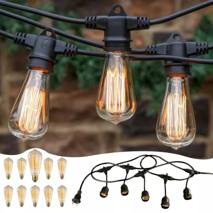 Close-up of three warm vintage LED Edison bulbs hanging from a black outdoor string light cable.